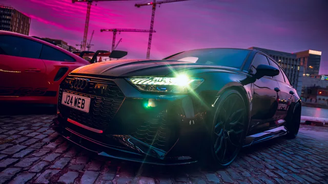 Low-angle Audi RS6 portrait under coloured city lighting