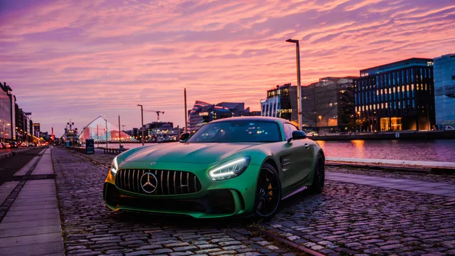 Green Mercedes-AMG beside the river at sunset