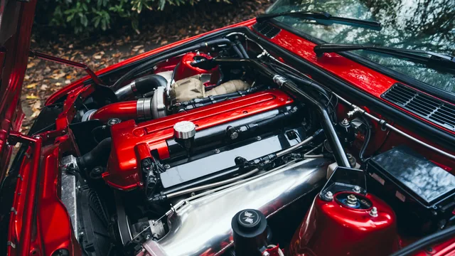 A detailed view of the engine bay of a red BMW