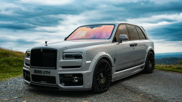 A silver Rolls-Royce against a wide countryside backdrop