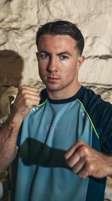 An outdoor sportswear portrait against textured stone