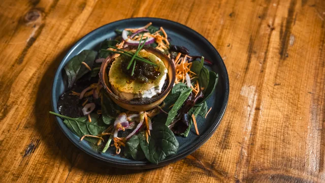 An overhead view of a plated dish on a wooden table