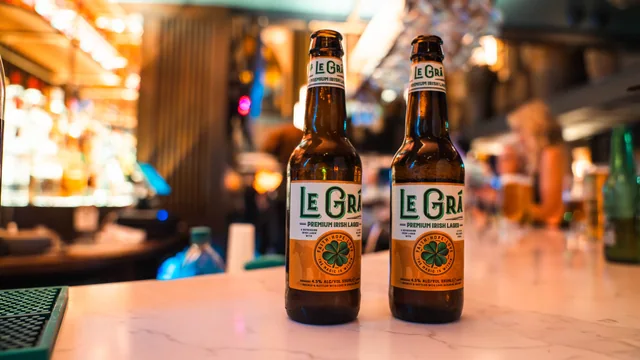 Two Le Grá bottles photographed on a warmly lit bar