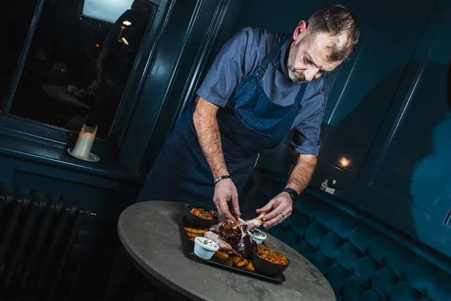 A chef carefully finishing a plate of food