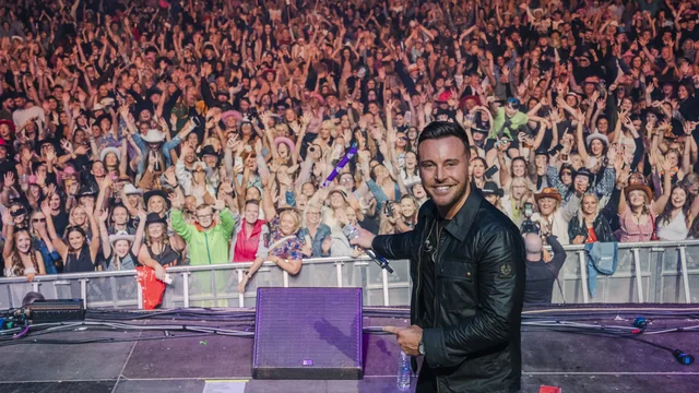 Nathan Carter on stage with a packed crowd behind him