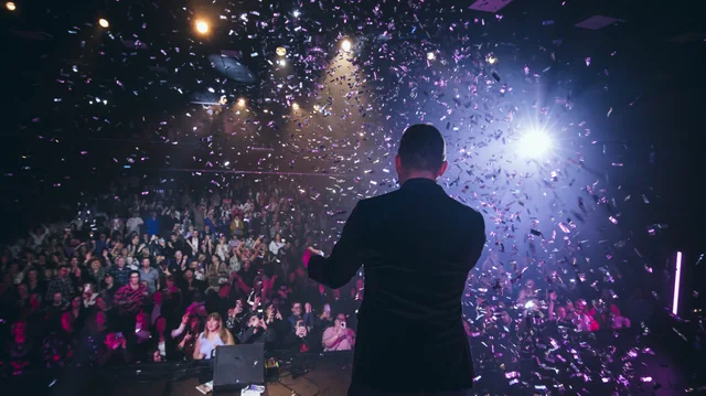 A performer facing the audience as confetti fills the air