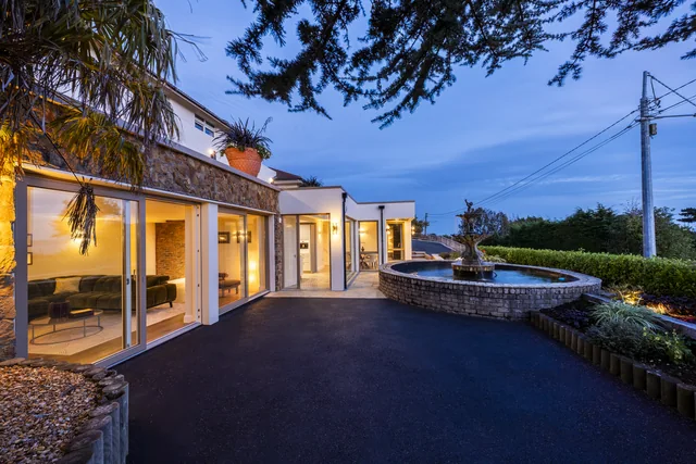 A house exterior and driveway photographed at dusk