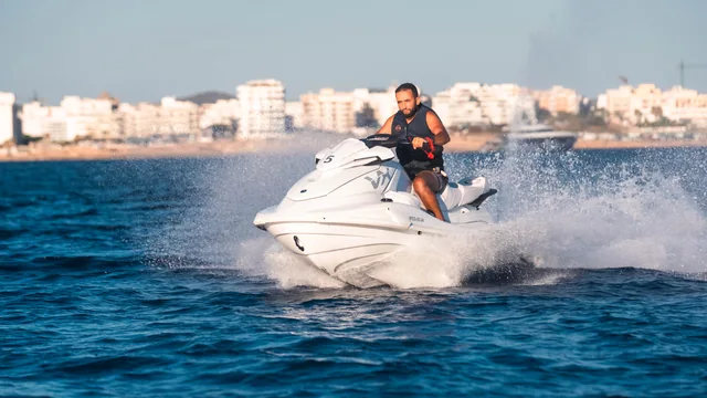 A jet ski in motion with the coast behind it