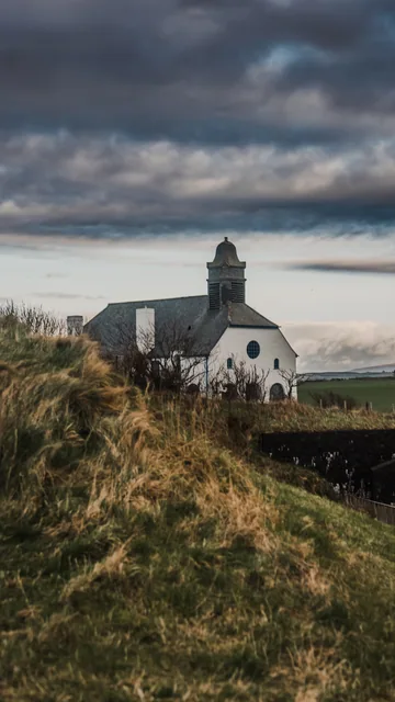 A coastal building beneath a dramatic sky
